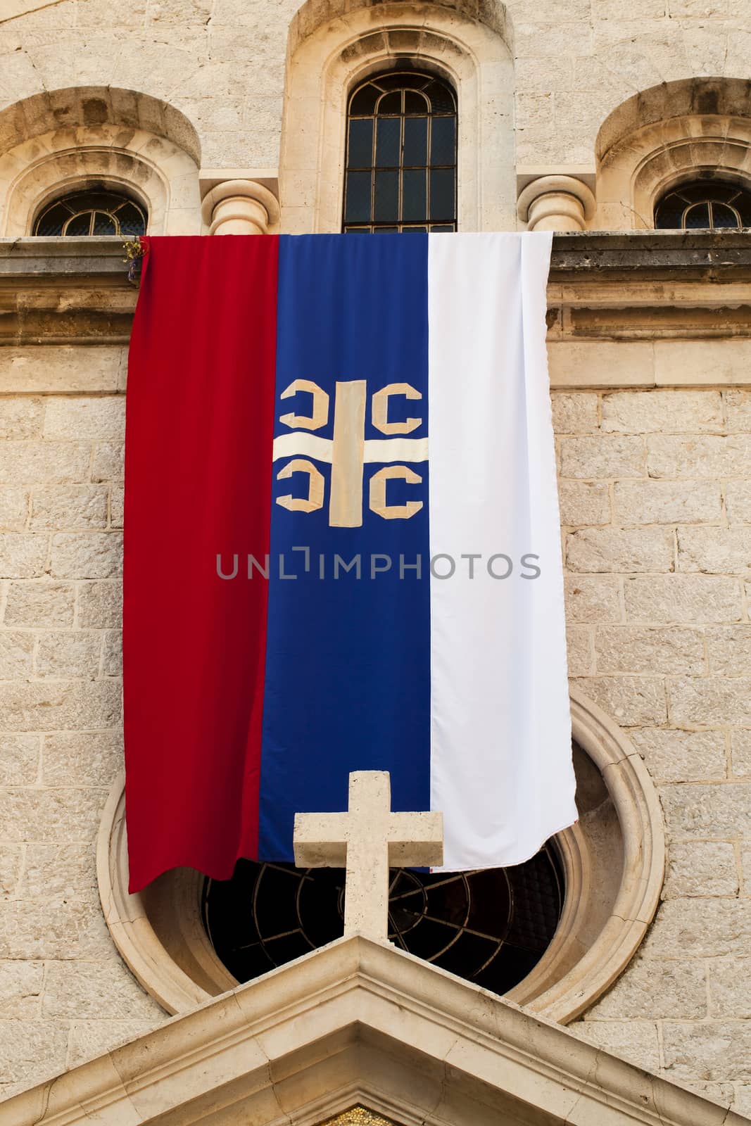   the flag of the Serbian orthodox church being on ancient church in the city of Kotor, Montenegro