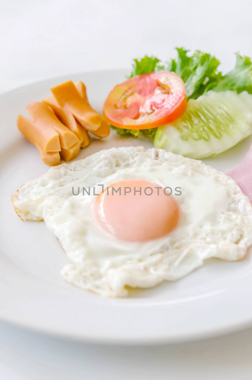 Fried eggs and sausage on a white  plate