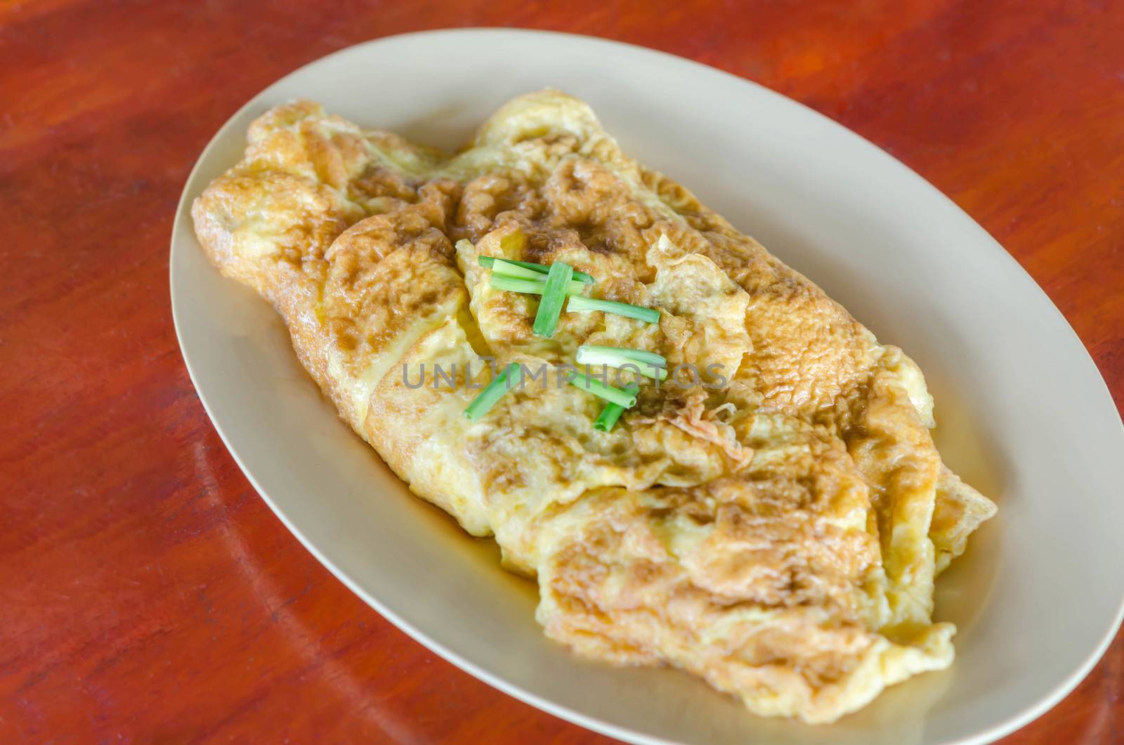 Thai omelette  or scrambled eggs with spring onion on dish