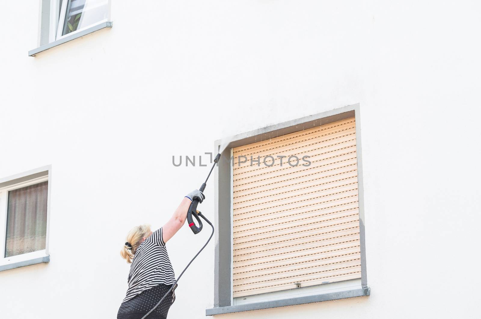 Exterior cleaning and building cleaning a gable wall with high pressure water jet.