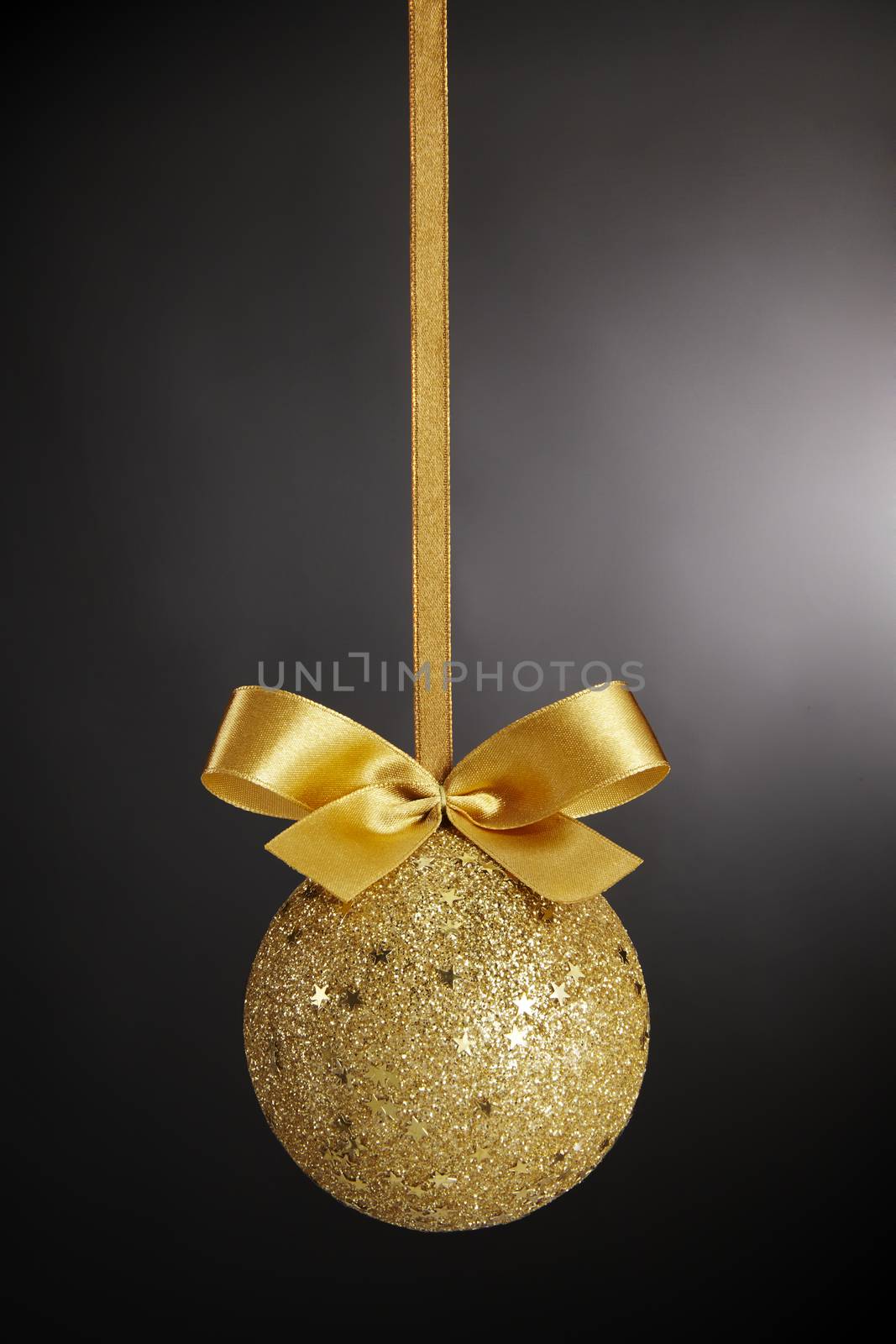 Gold Christmas ball with bow on black background