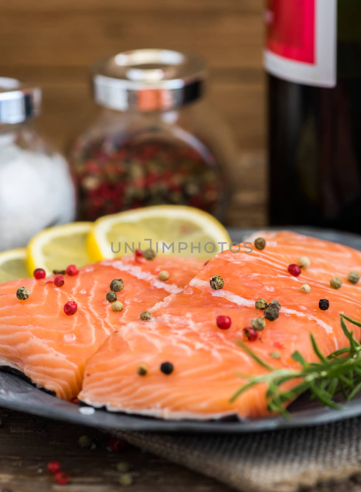 Raw Salmon Fish Fillet with Wine, Lemon, Spices and Fresh Herbs on Plate