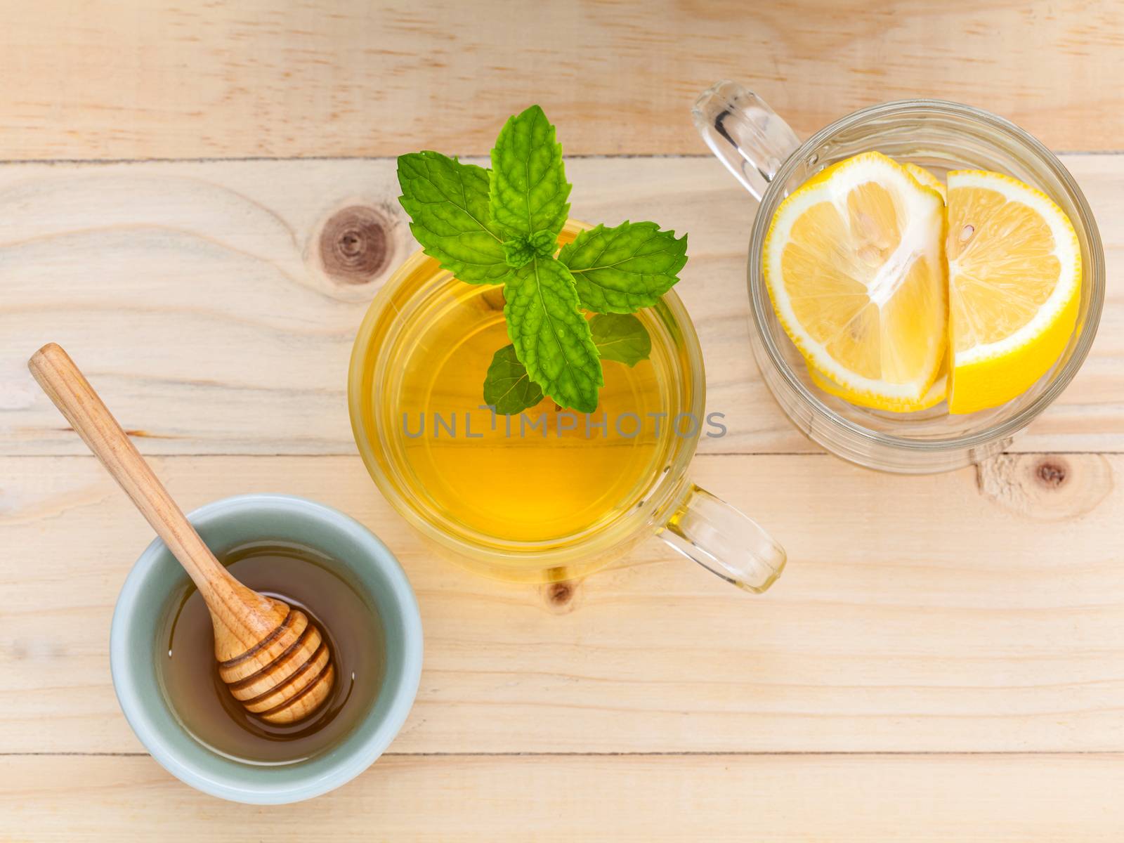 Cup of herbal tea with fresh green mint ,honey and lemon on wooden background.