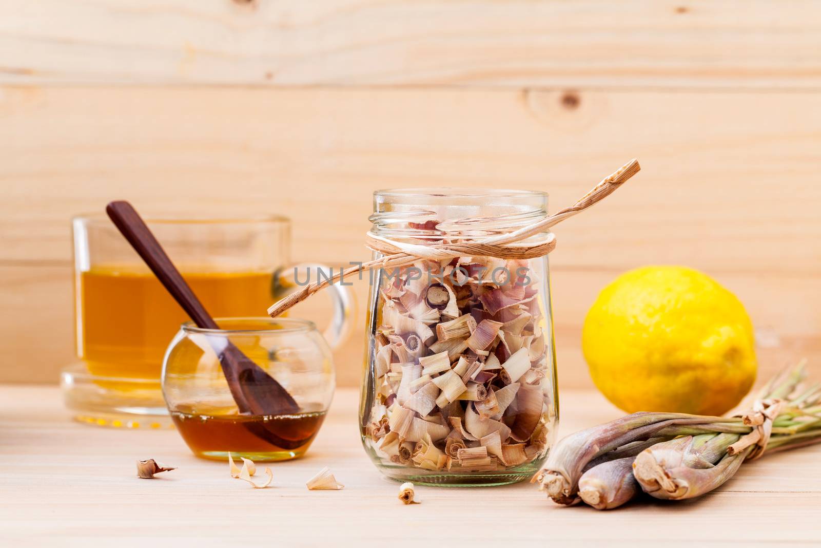 Cup of herbal tea with dried lemon grass ,honey and lemon on wooden background.