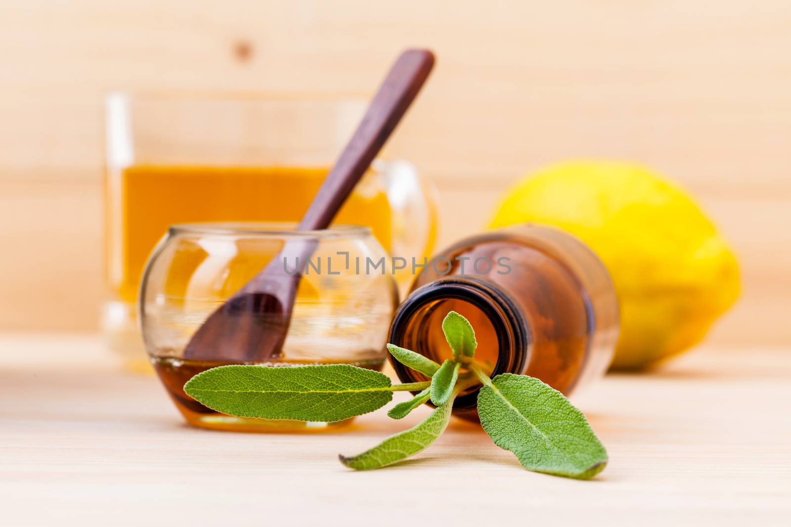 Cup of herbal tea with  fresh sage ,honey and lemon on wooden background.