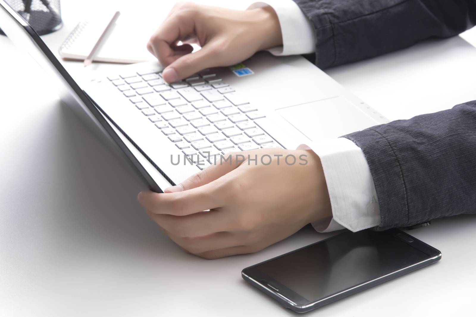 Asian man's hands typing on laptop keyboard