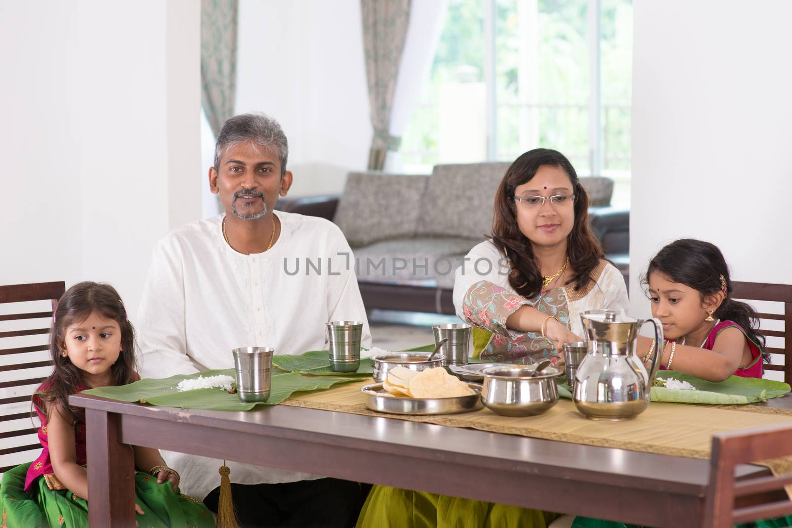 Indian family dining at home. Photo of India people eating rice on dining table. Traditional home cook meal.