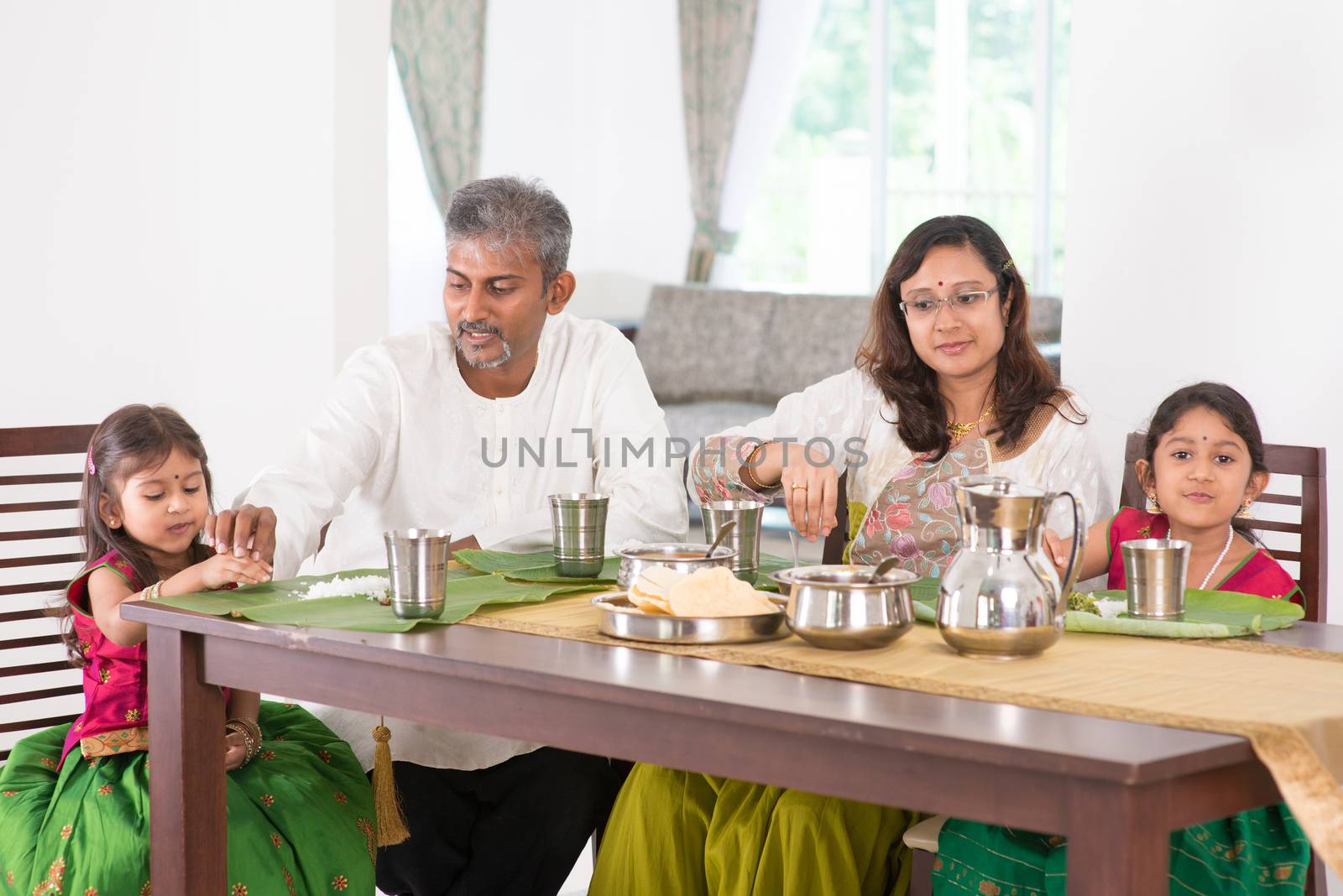 Indian family dining at home. Photo of Asian people eating rice with hands. India culture.