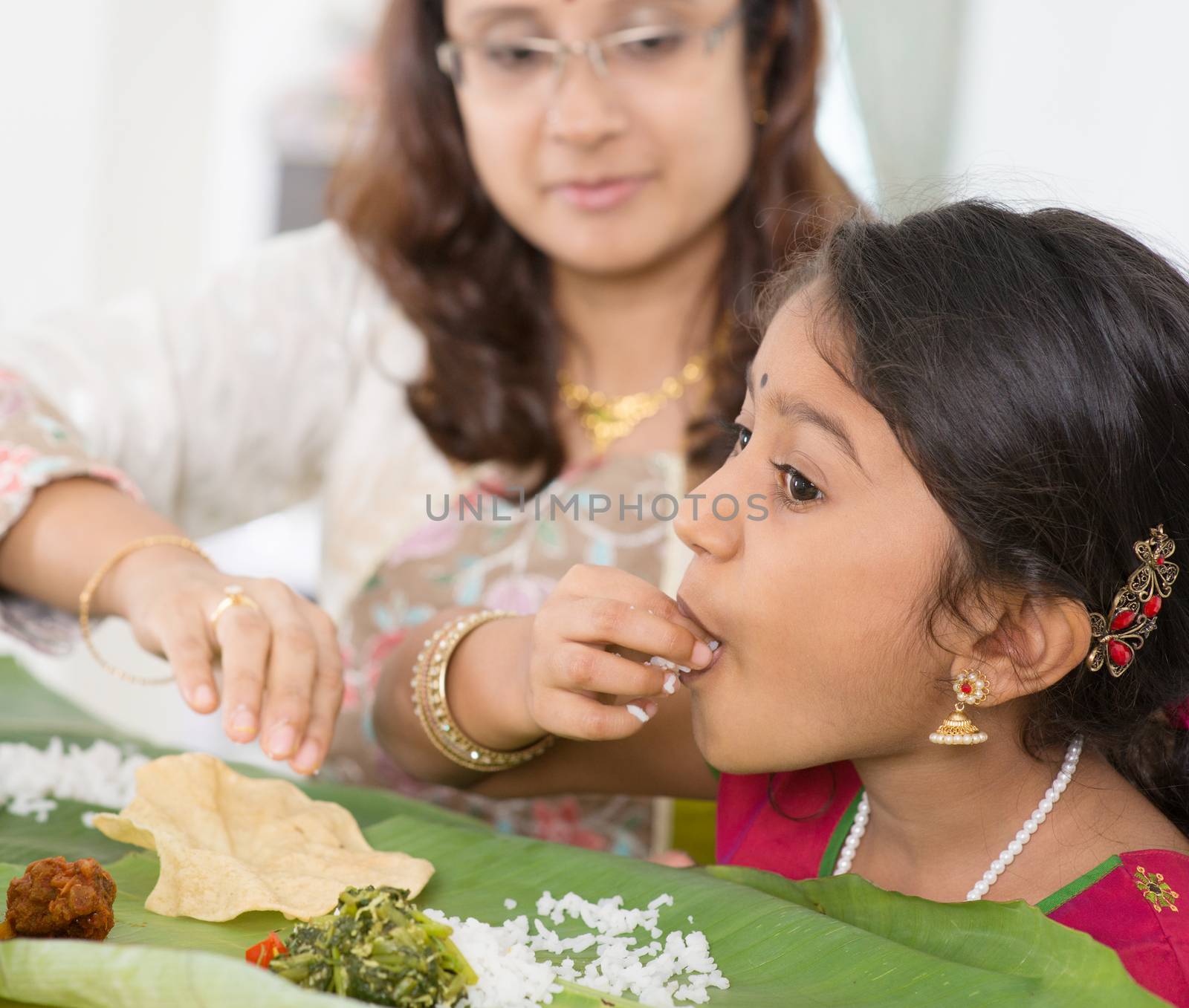 Indian family dining at home. Candid photo of Asian people eating rice with hands. India culture.