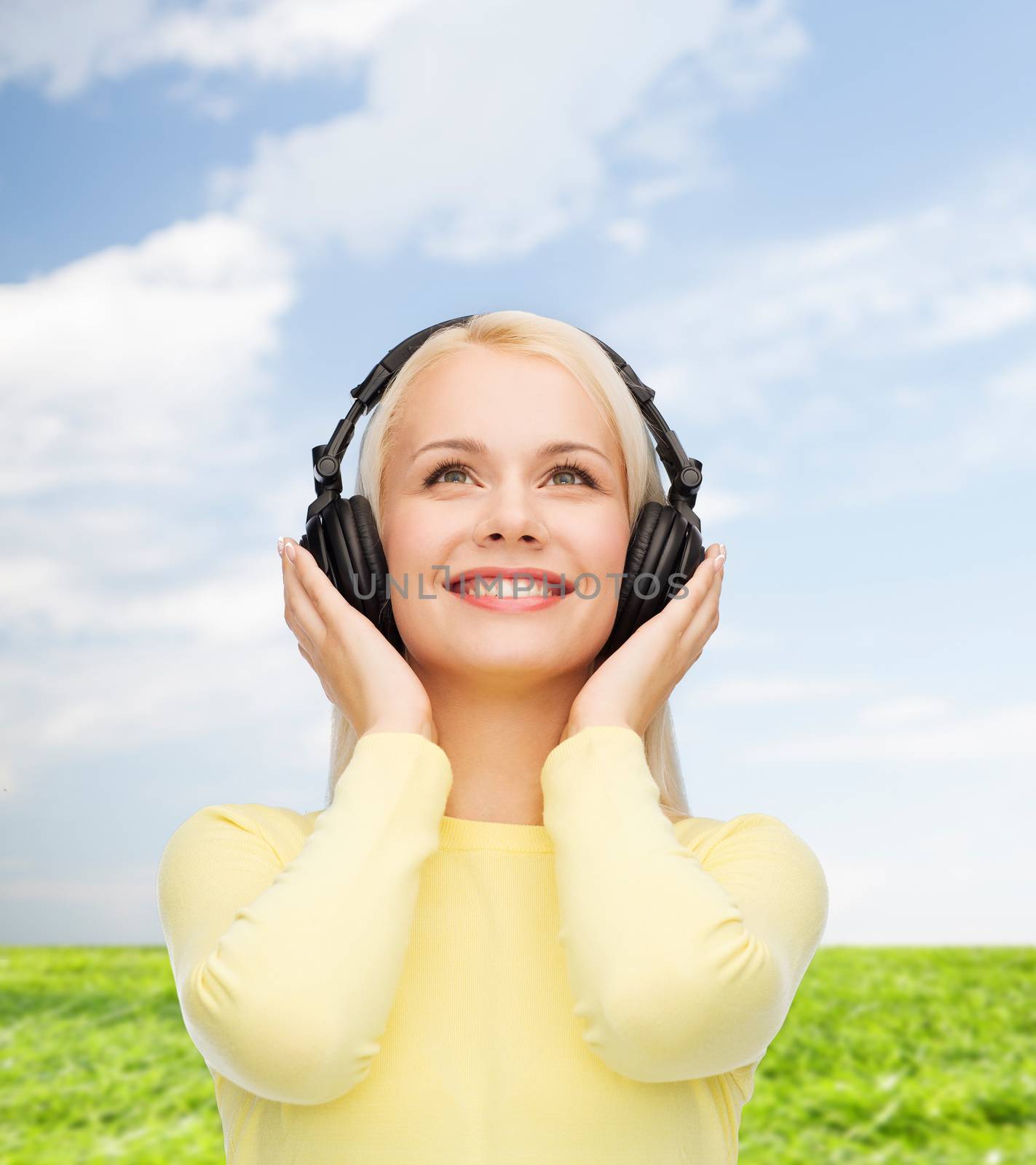 smiling young woman with headphones by dolgachov