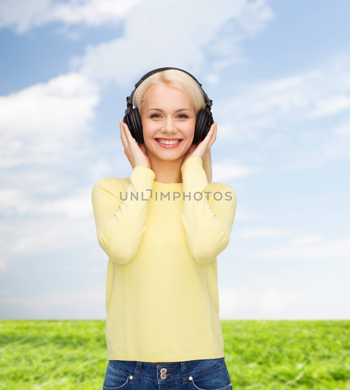 smiling young woman with headphones by dolgachov