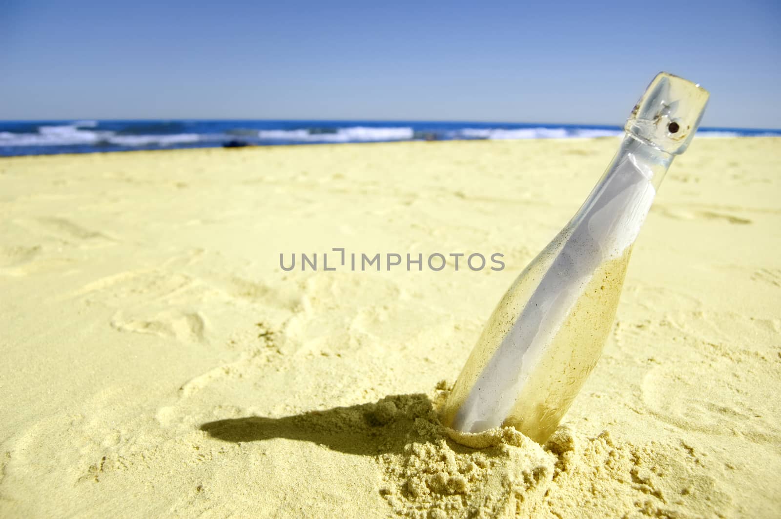 Message conceptual image. Message in a bottle on sand.