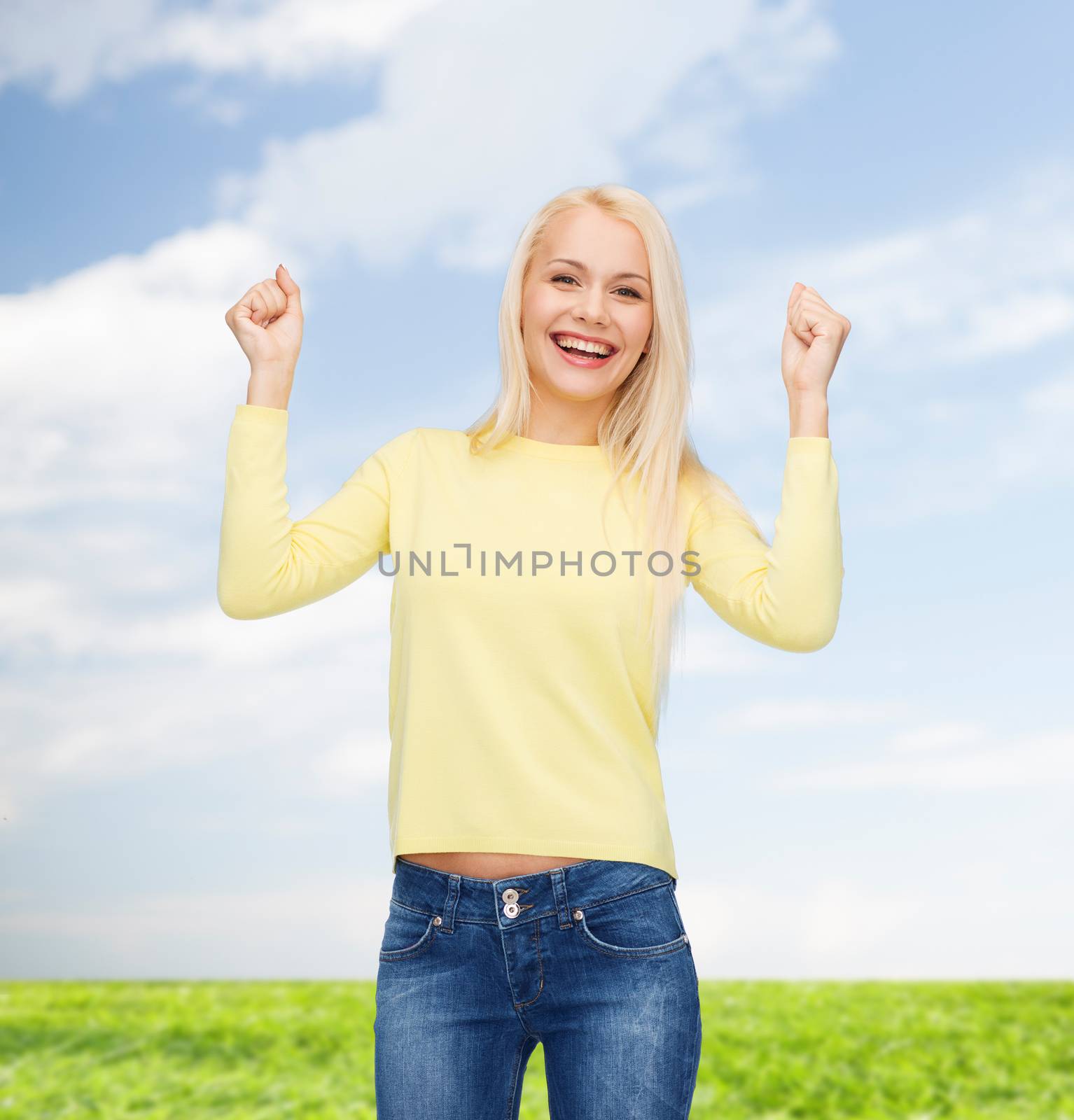 happiness and people concept - laughing young woman with hands up