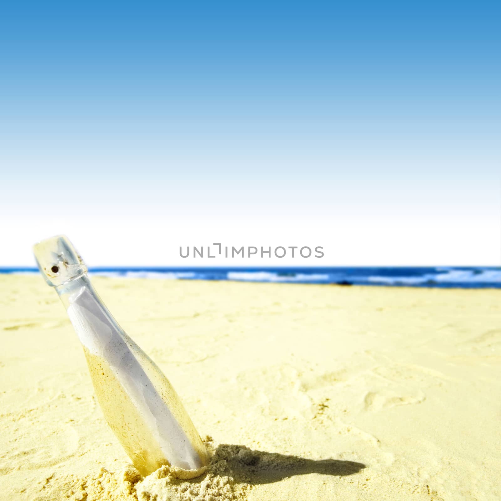 Message in a bottle on sand.