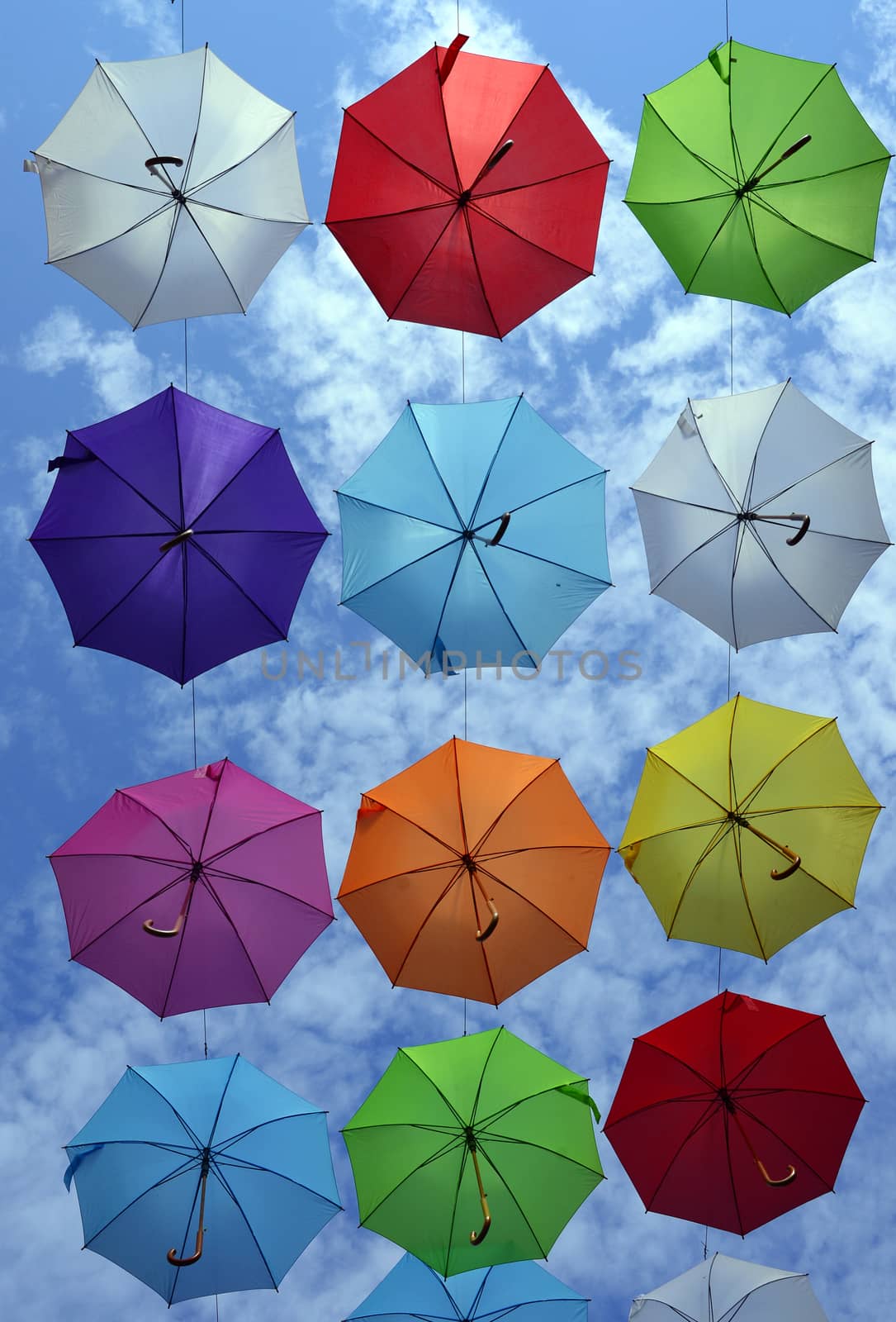many colorful hanged umbrella against blue sky