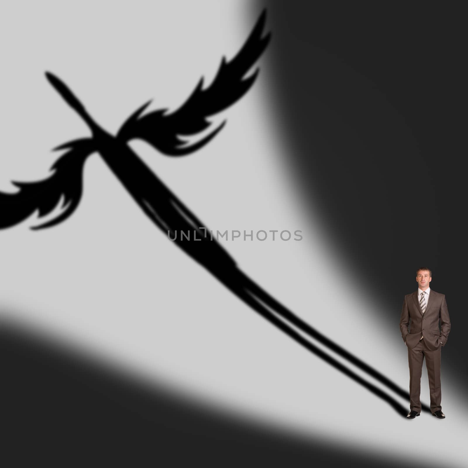 Businessman with angel shadow on gray wall background