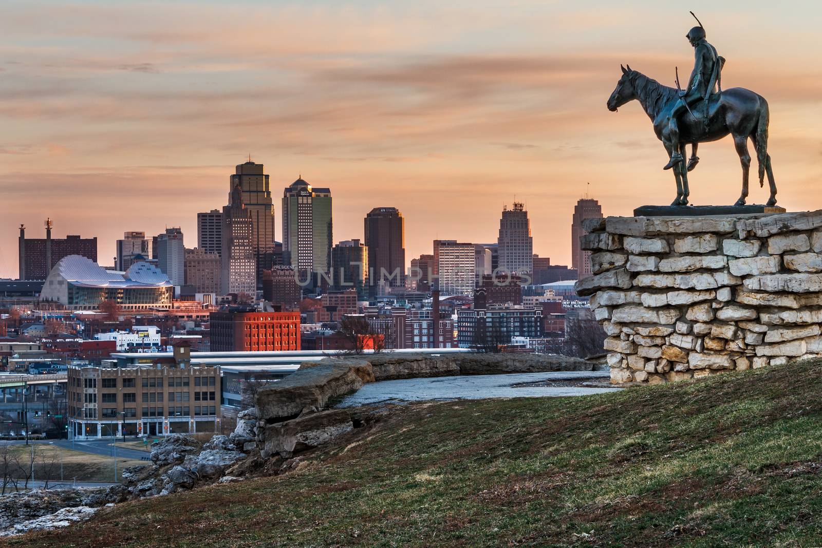 Kansas City, Missouri, USA on March 22, 2014.  A image of the Kansas City Scout overlooking Kansas City at sunrise.  The Indian Scout is known as a Kansas City landmark and symbol of the city. The scout overlooks the Kansas City Skyline.
