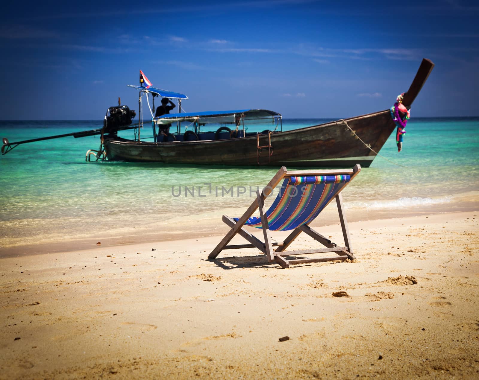 Exotic beach holiday background with beach chair and long tail boat - Thailand ocean landscape