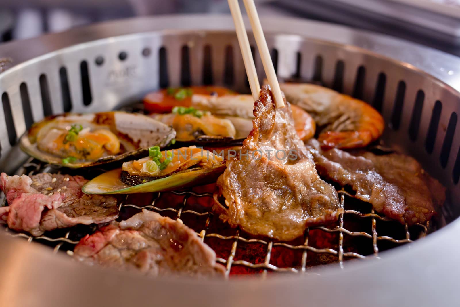 Mixed Roasted Meat and Seafood and Chopsticks on the BBQ Grill on roast.