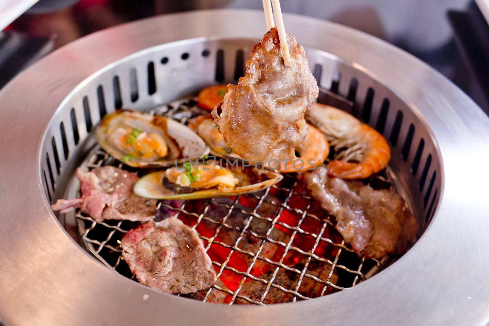 Mixed Roasted Meat and Seafood and Chopsticks on the BBQ Grill on roast.