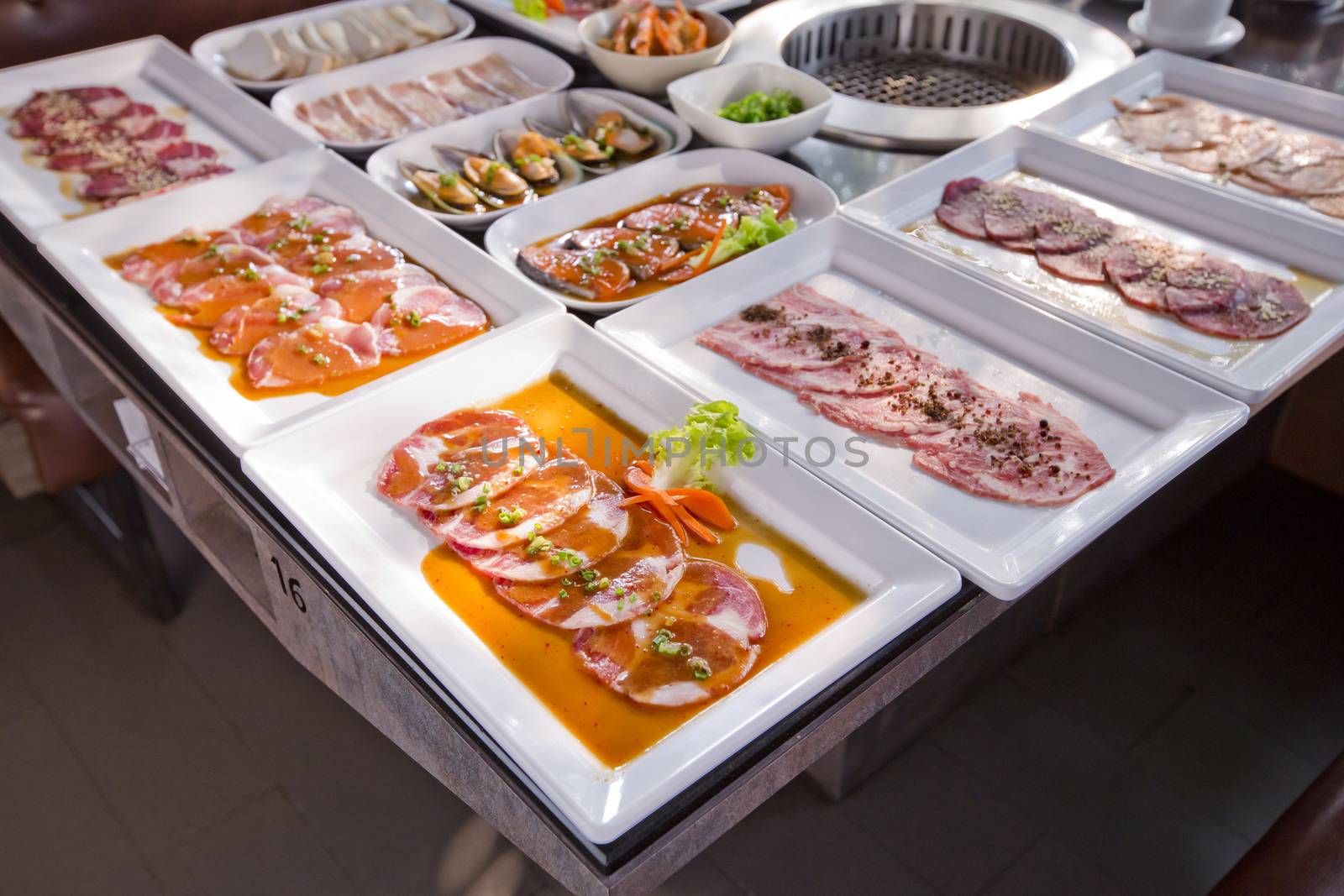 assorted meat and seafood uncooked and roaster ready to be grilled