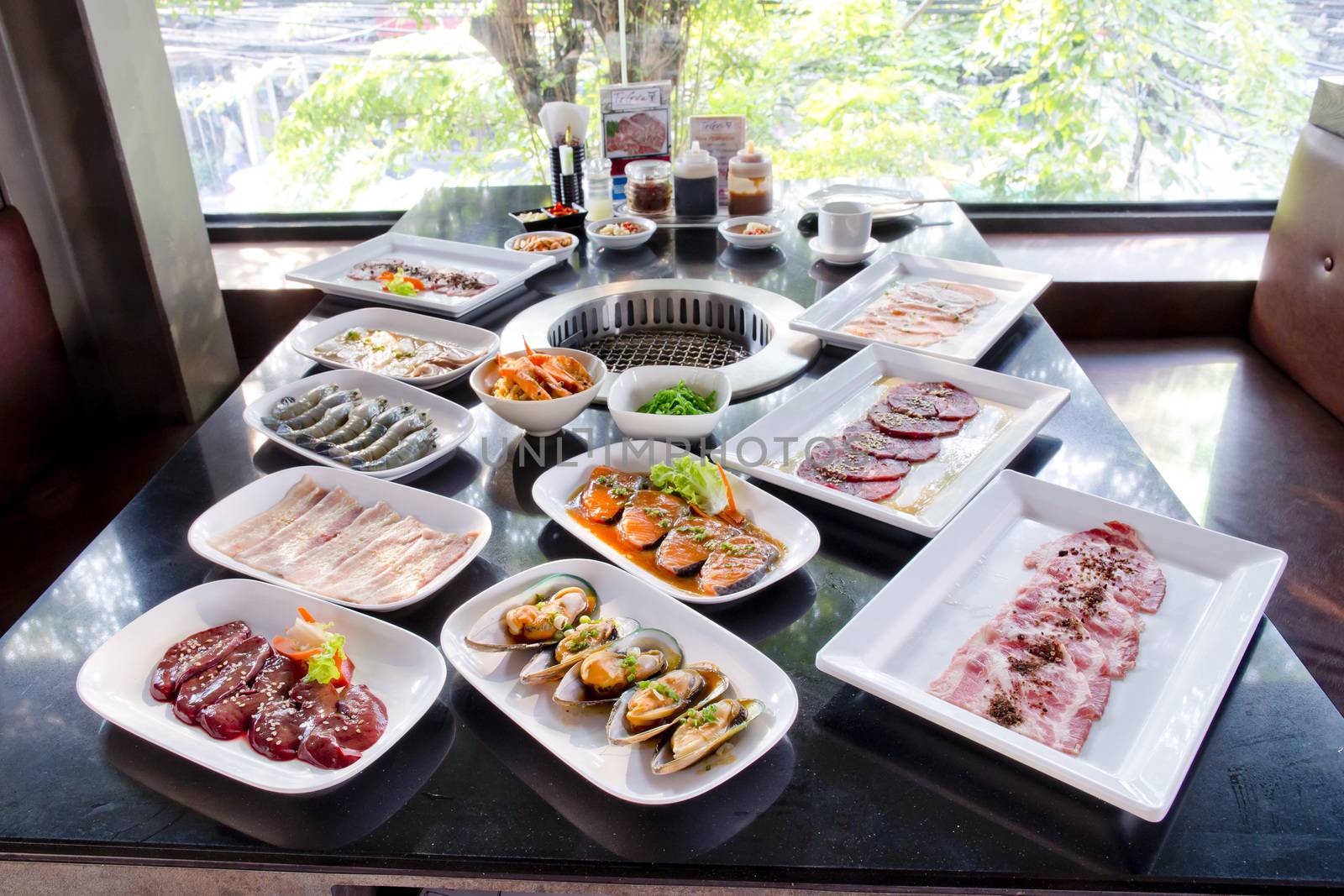 assorted meat and seafood uncooked and roaster ready to be grilled