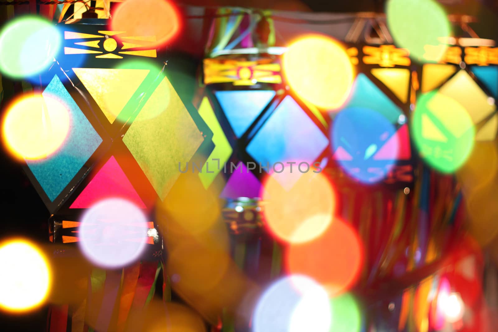A view of traditional Diwali lanters through colorful lights out of focus.
