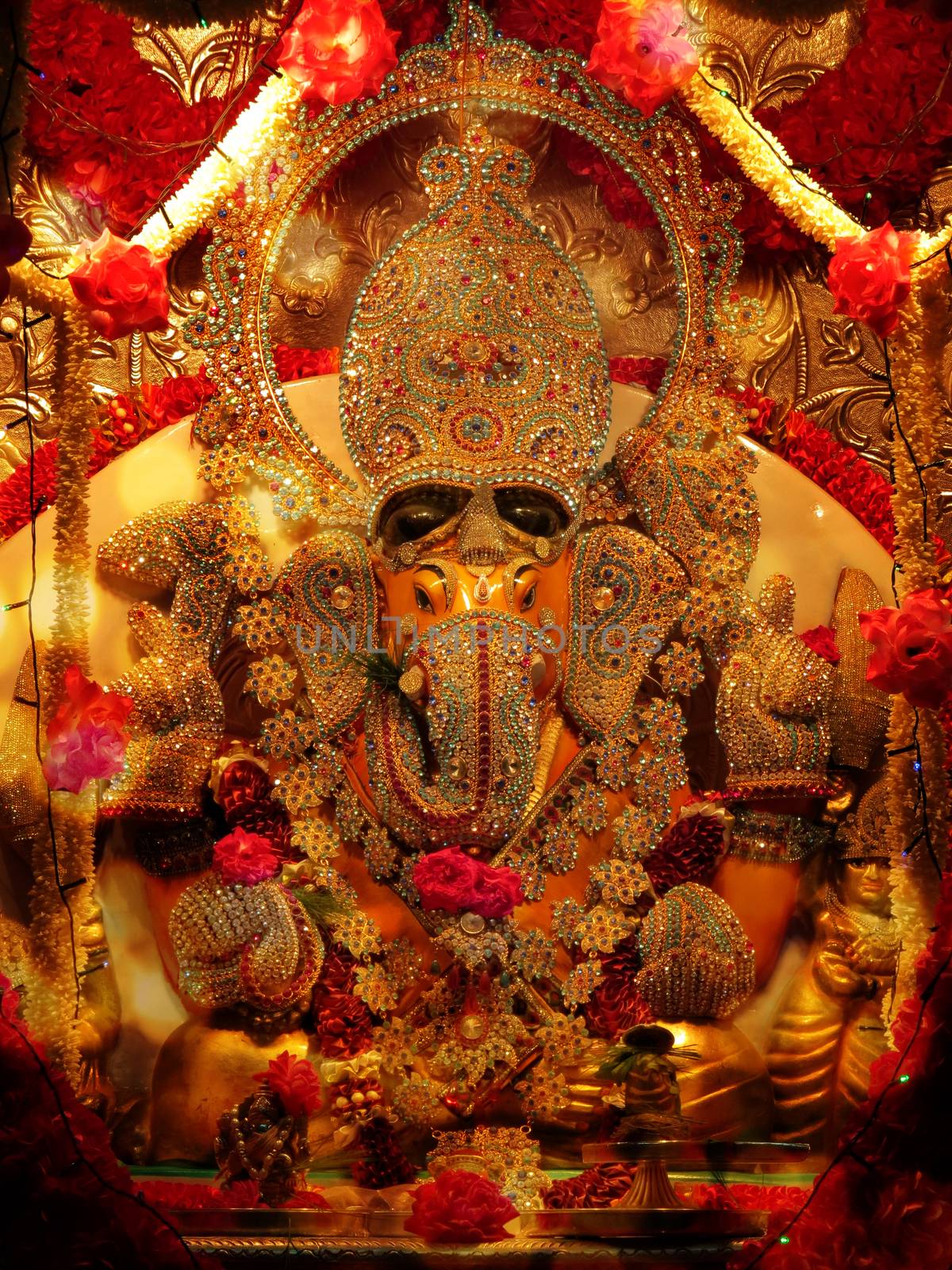 A lord Ganesha idol studded with precious gemstones in a Hindu temple during Ganesh festival                               