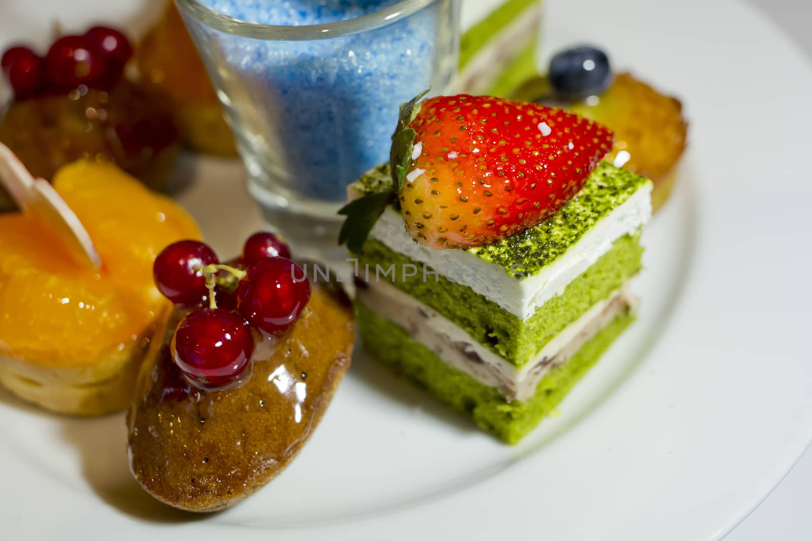 Collection of different delicious desserts and cakes in white plate