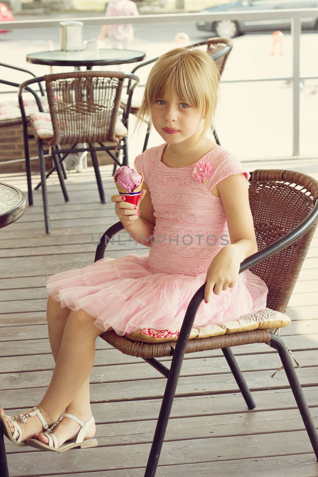 Pretty girl eating ice cream in a street cafe