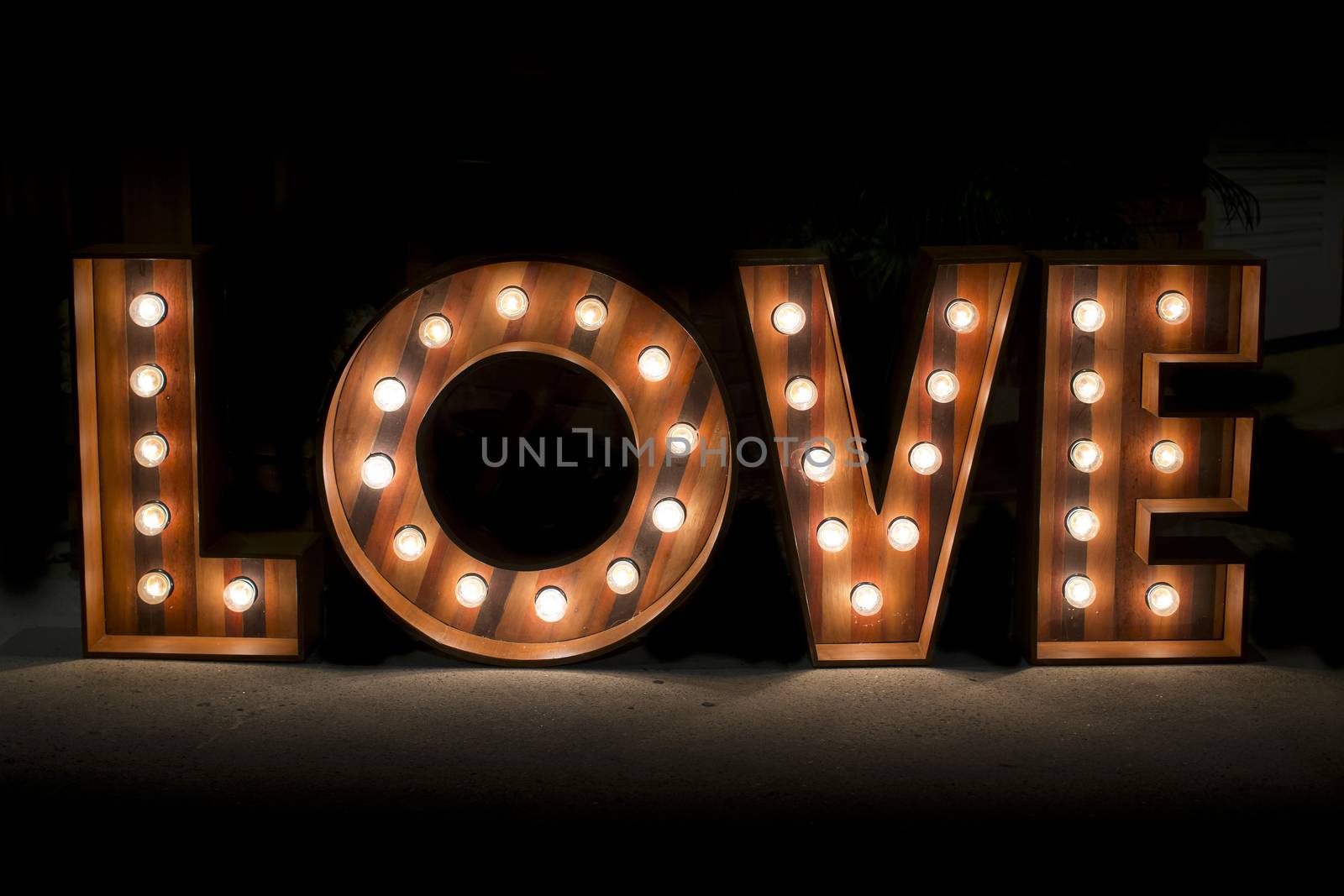 Wording Love sign with light bulb isolate on black background