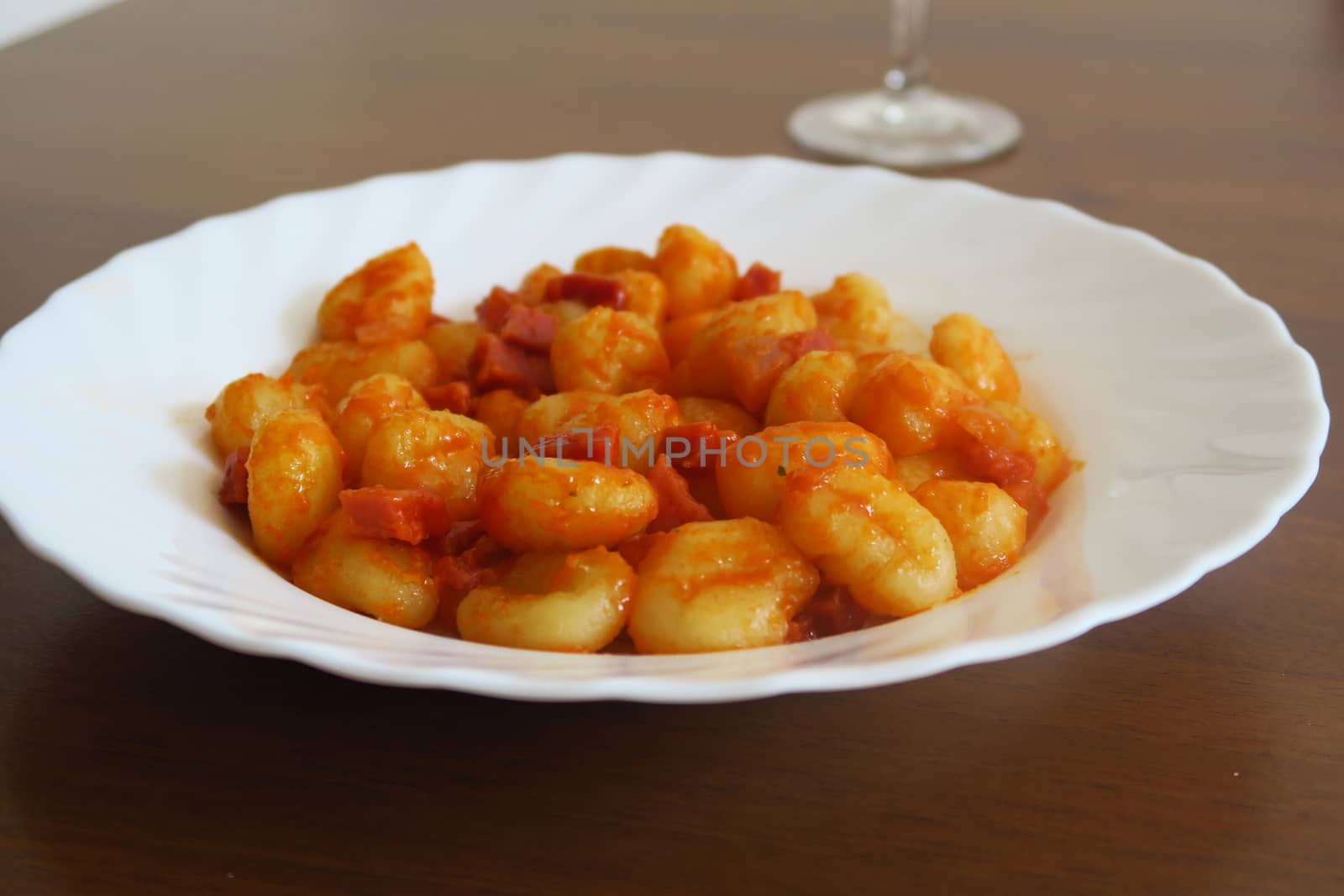 Potato dumplings, a typical Italian pasta called"Gnocchi", here served with tomato sauce and ham