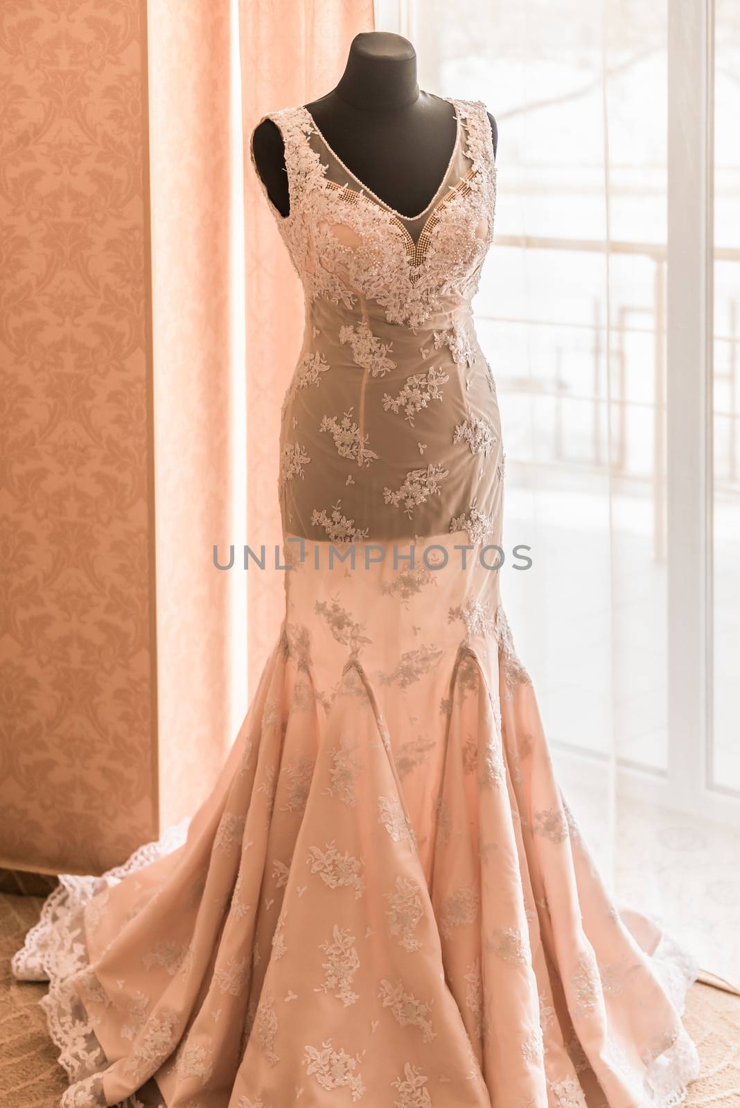 wedding dress on a mannequin in front of a window