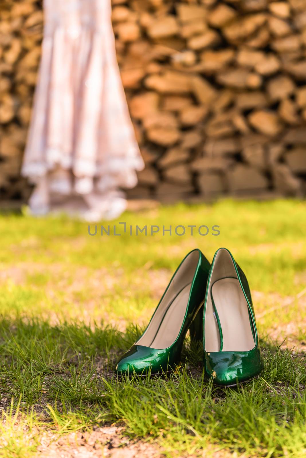 wedding emerald bridesmaid shoes on the green grass on the background of the dress