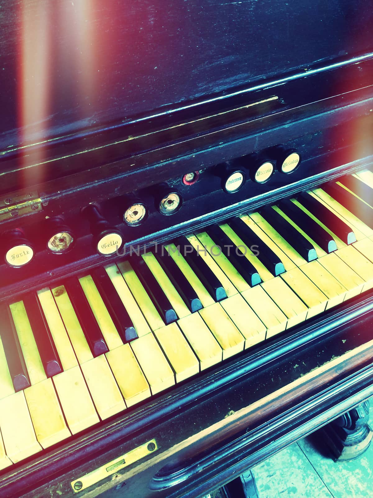 Antique reed organ. Retro style photo with light leaks.