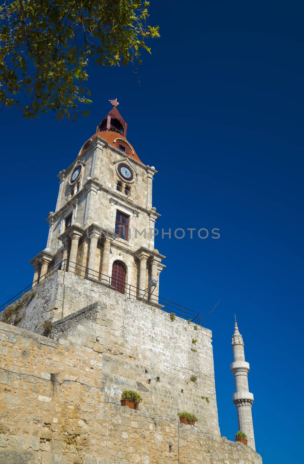 Clock tower and mosque minaret of old Rhodes by allouphoto
