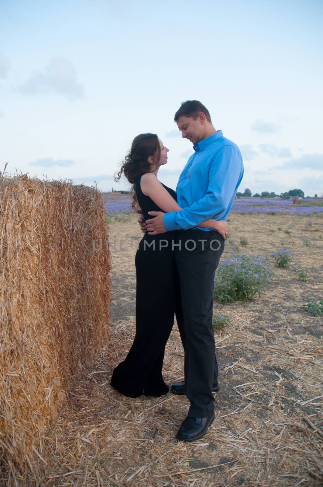 Couple sitting on a hay stack . by LarisaP