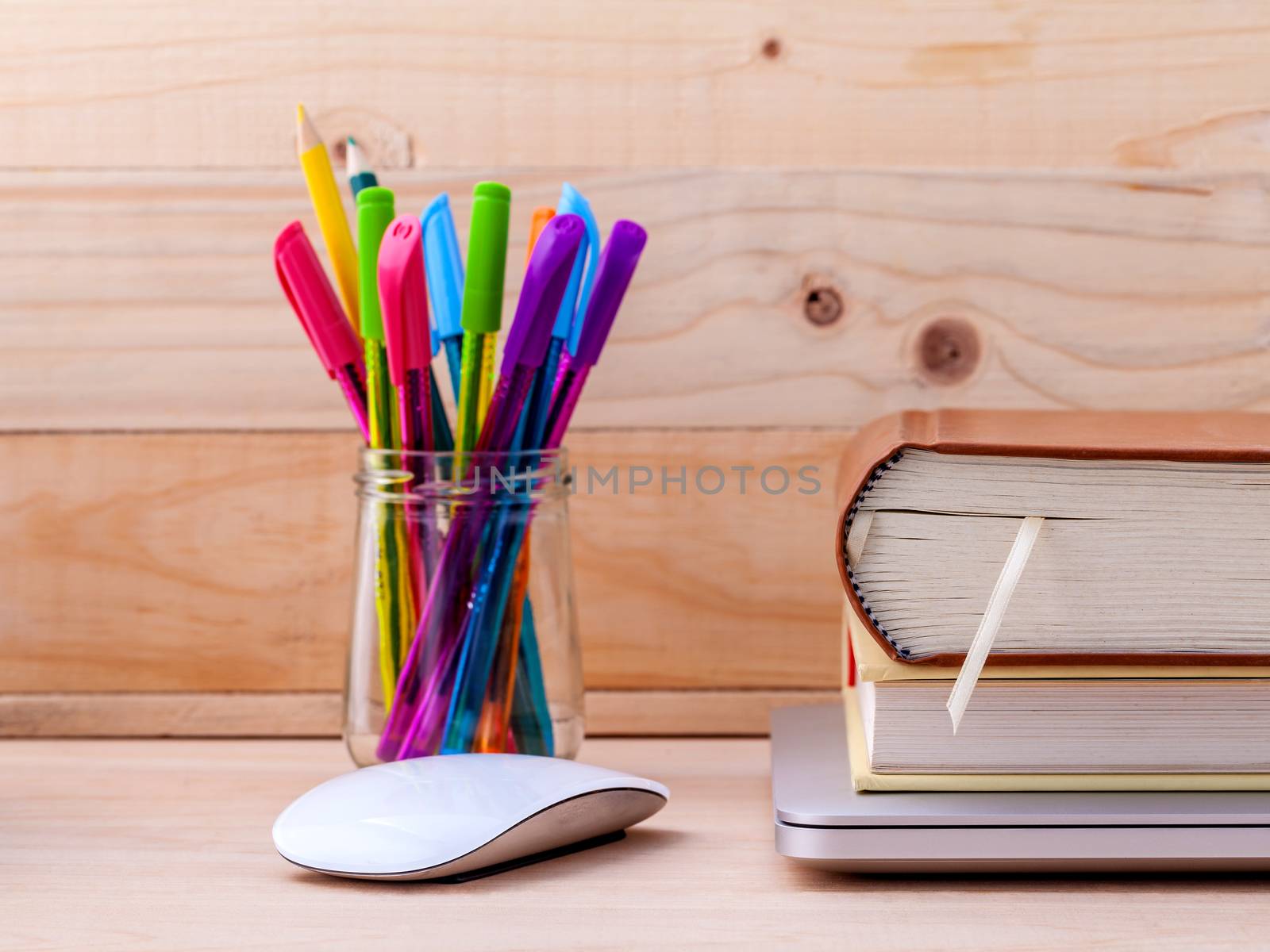 Back to school concept with school supplies laptop ,book, pen,mouse,and colored pencil on wooden table .