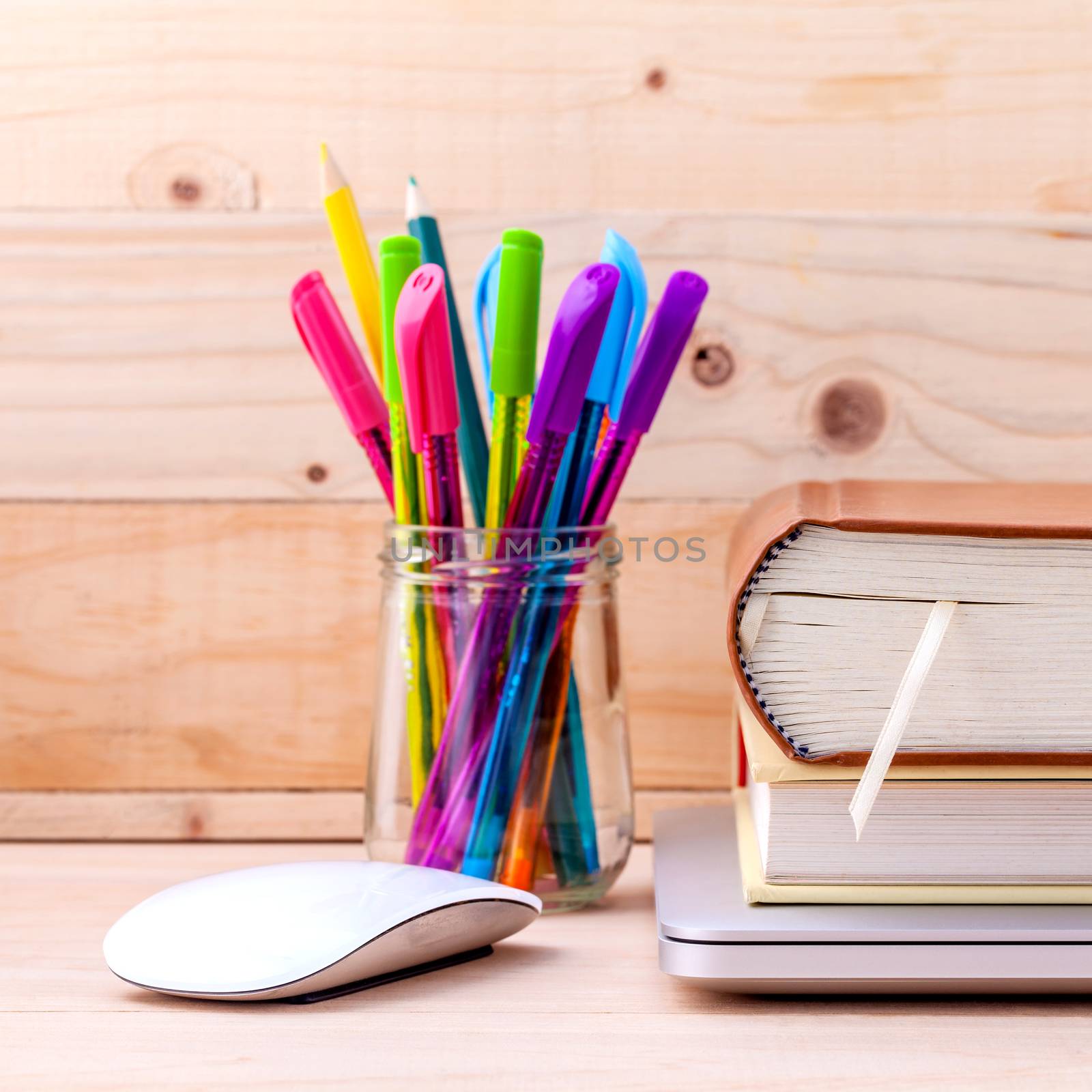 Back to school concept with school supplies laptop ,book, pen,mouse,and colored pencil on wooden table .
