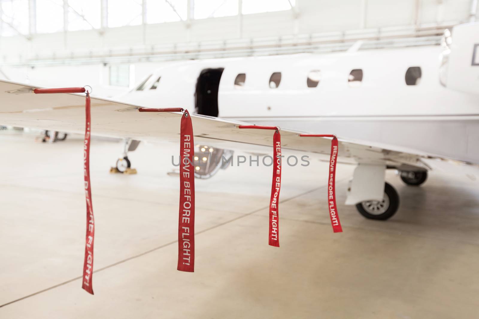 Airplane in Hangar with remove before flight Labels in red warning safety