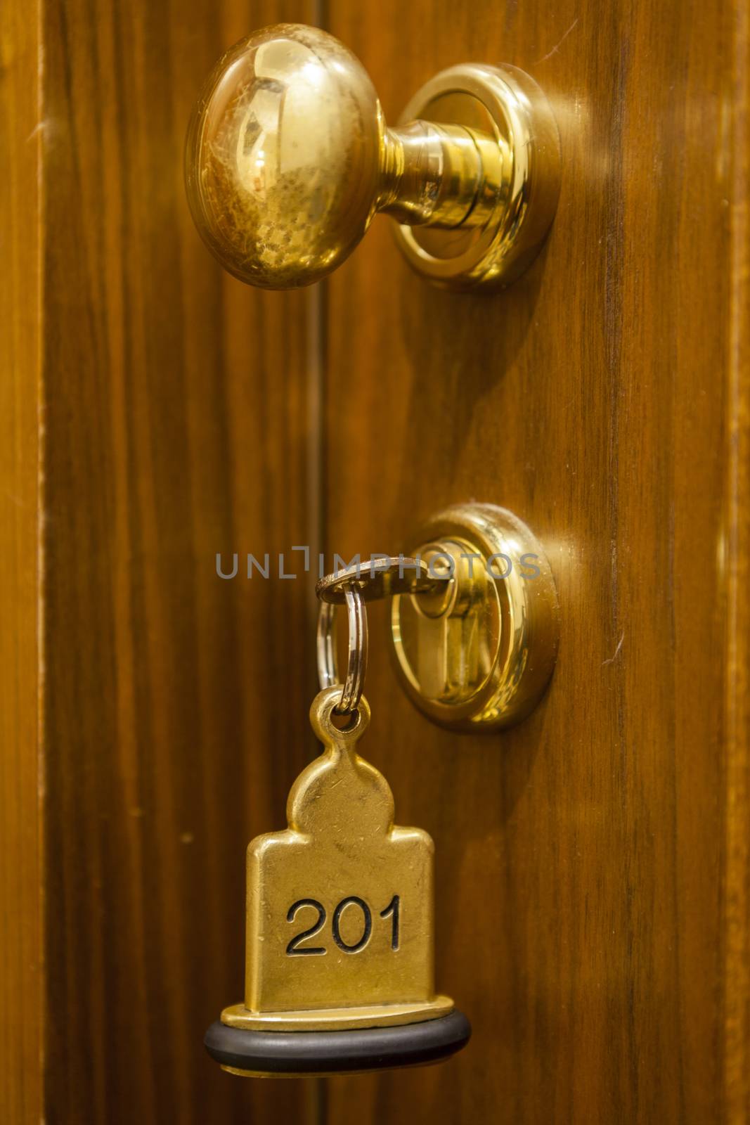 Hotel Room Key lying on Bed with keyring golden