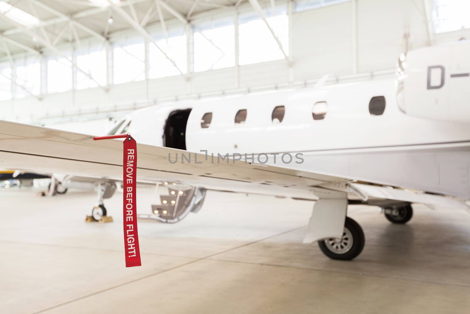 Airplane in Hangar with remove before flight Labels in red warning safety