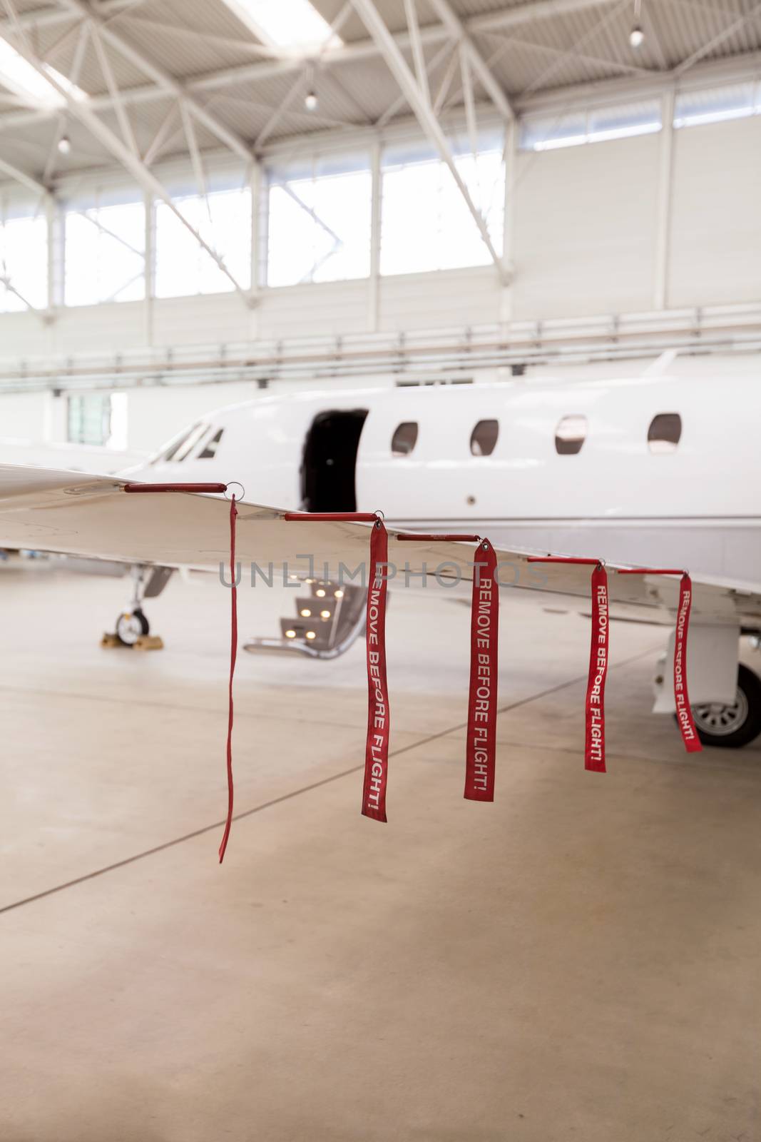 Airplane in Hangar with remove before flight Labels in red warning safety