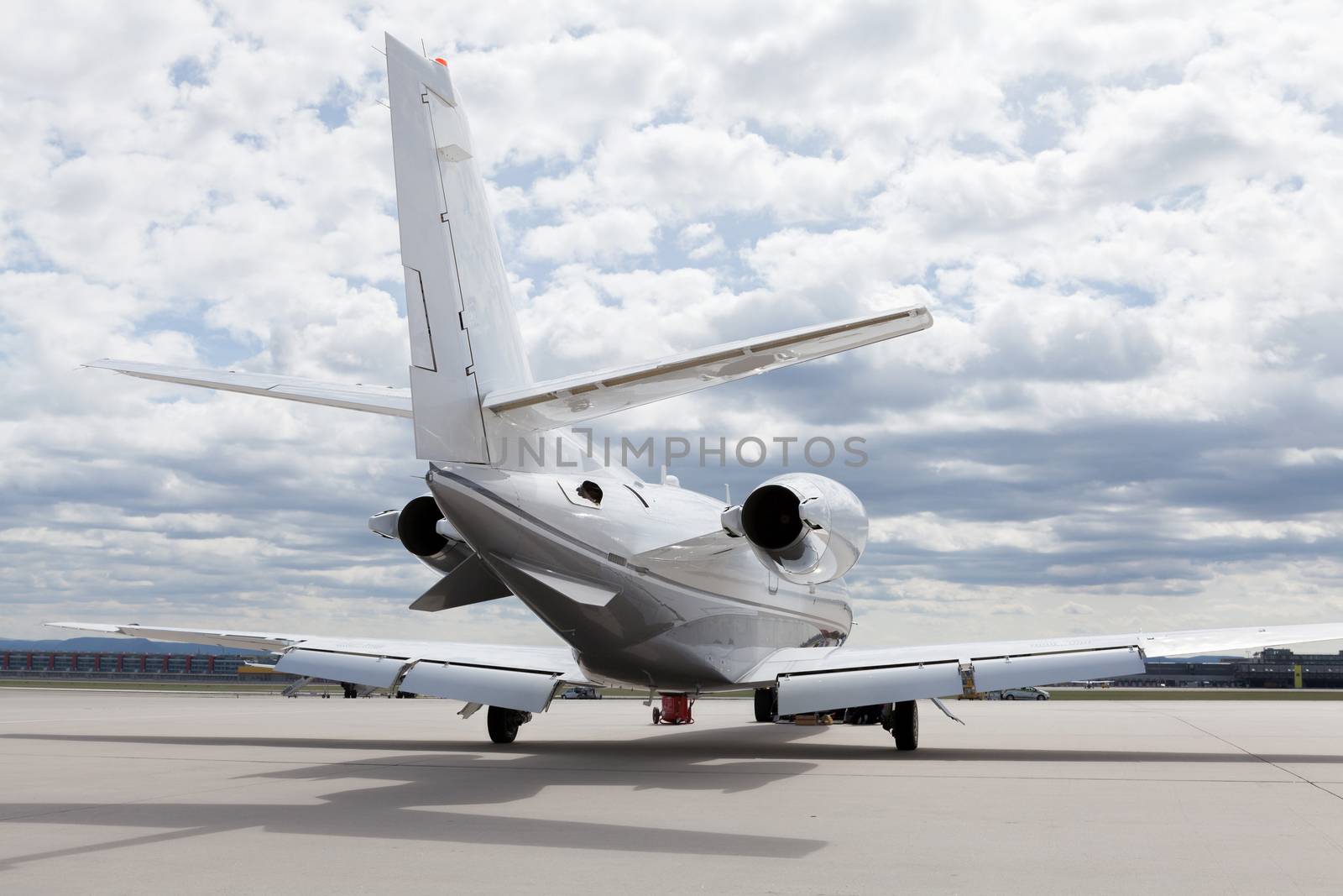 Aircraft learjet Plane in front of the Airport with cloudy sky and sun