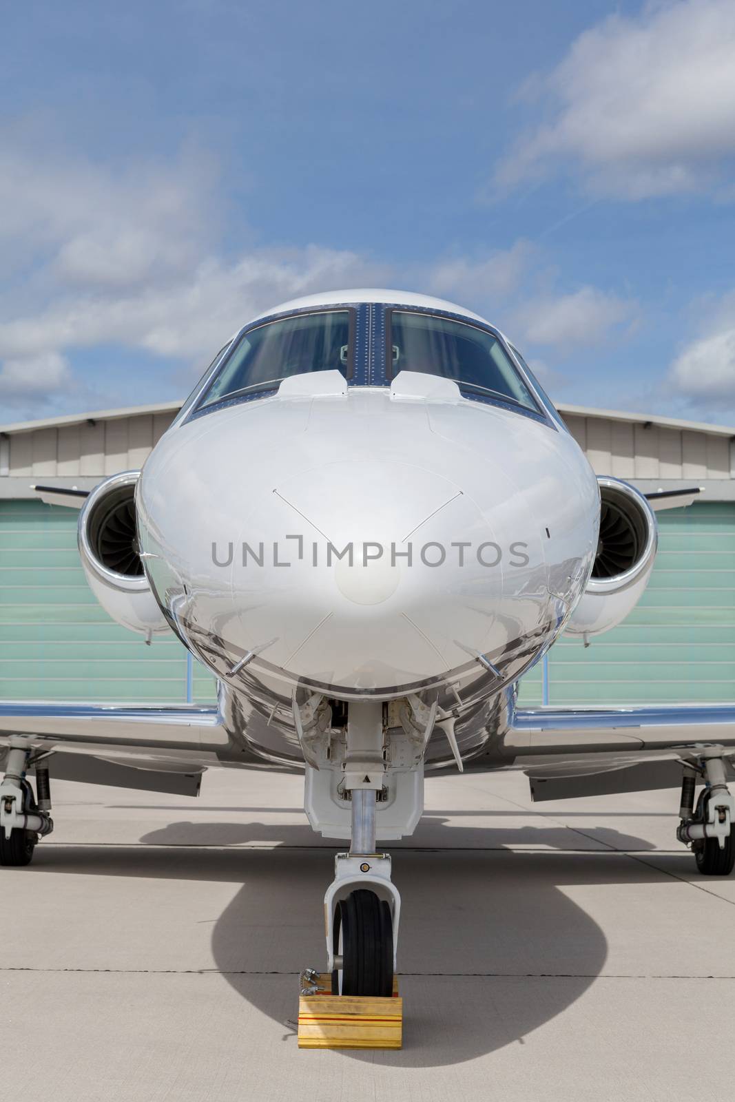 Aircraft learjet Plane in front of the Airport with cloudy sky and sun