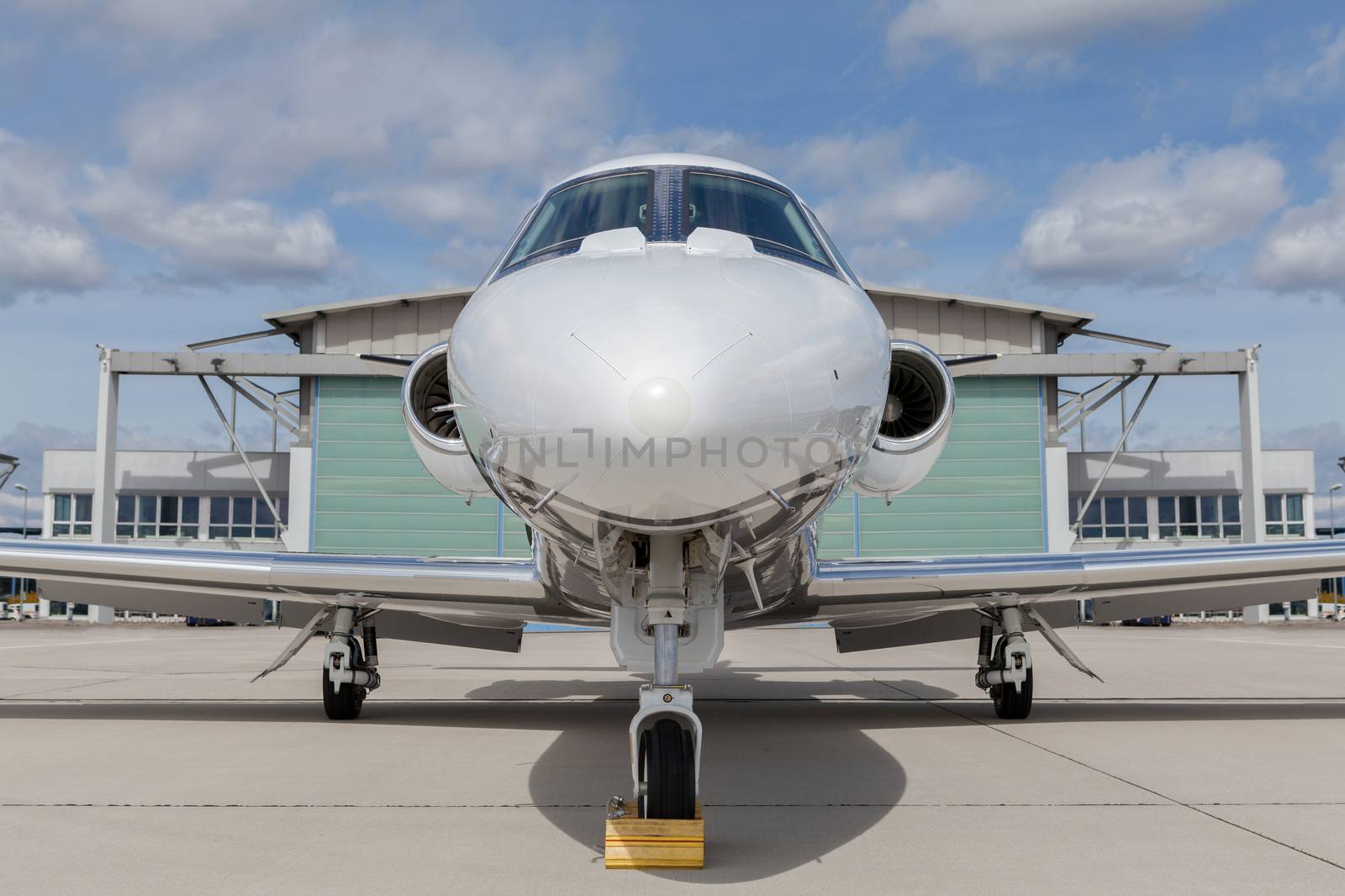 Aircraft learjet Plane in front of the Airport with cloudy sky and sun