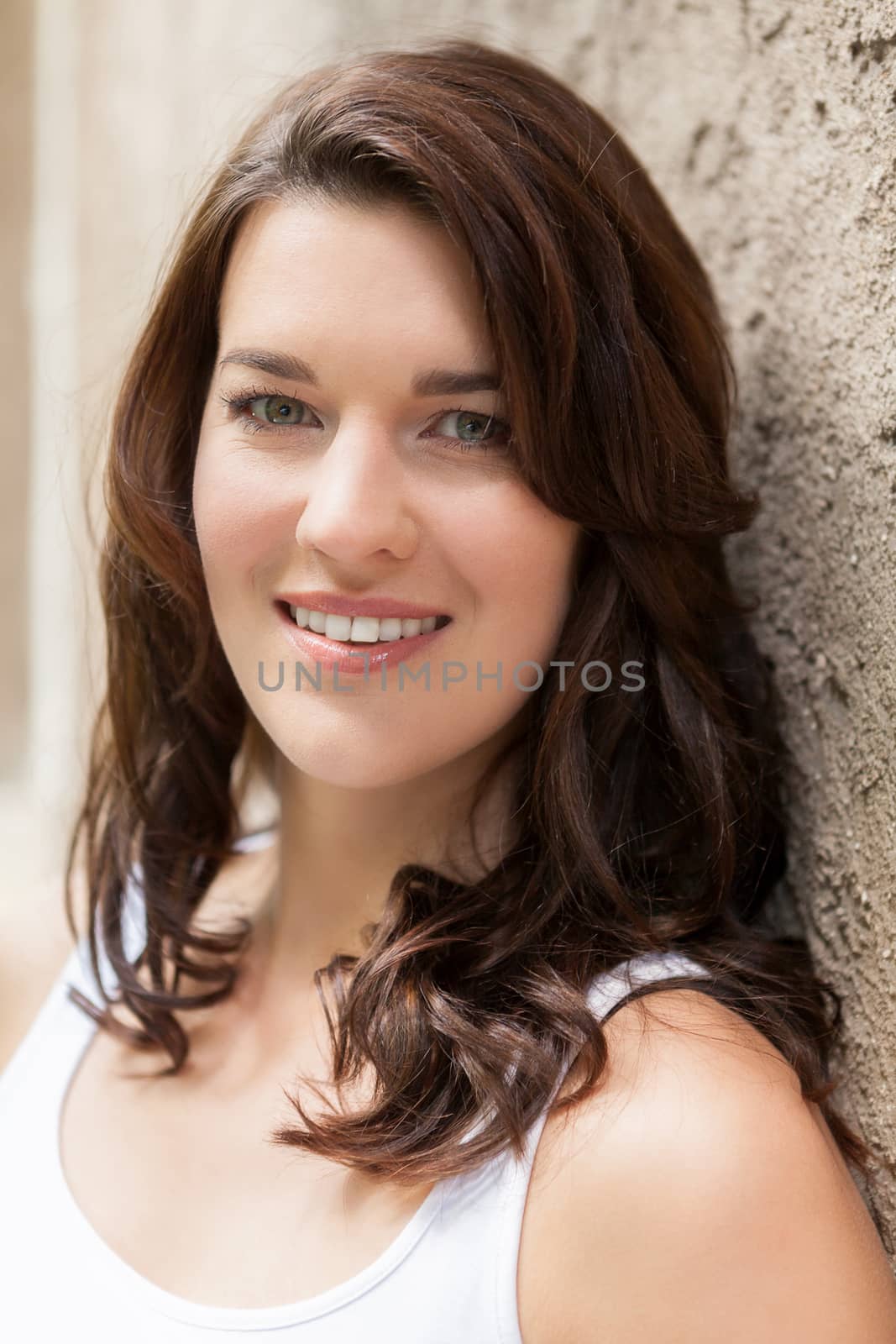 Portrait beautiful woman with dark hair smiling in the camera on grey background