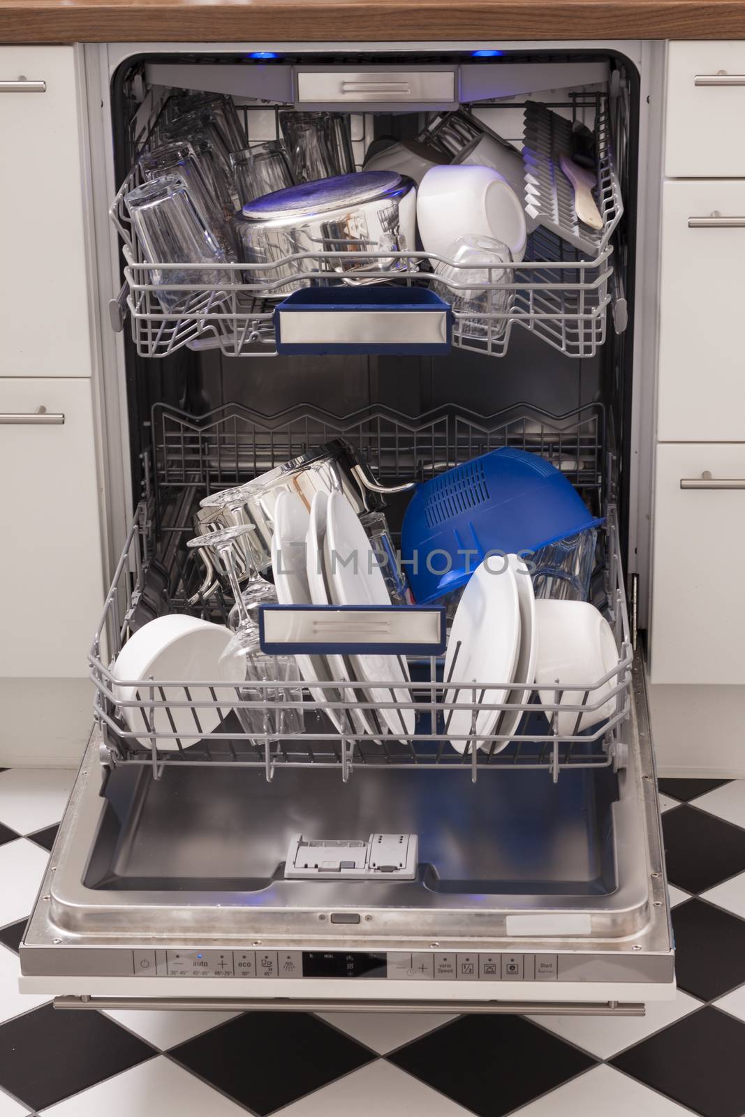 Dishwasher loades in a kitchen with clean dishes and blue light