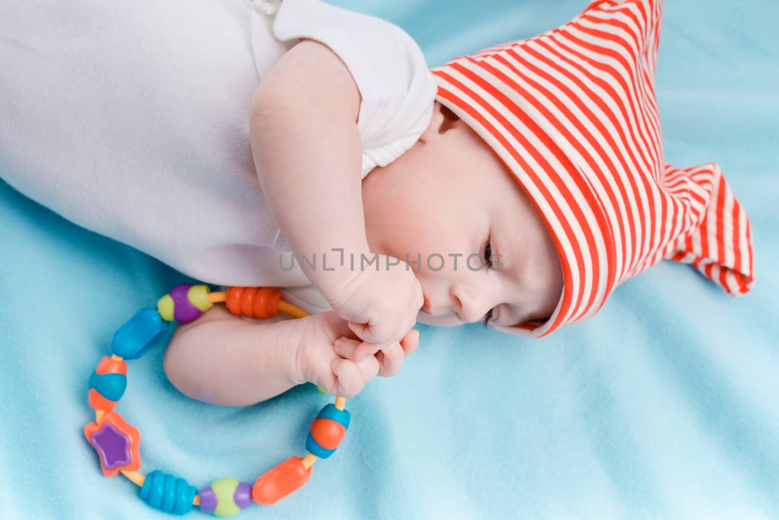Baby in hat lying on a blue plaid