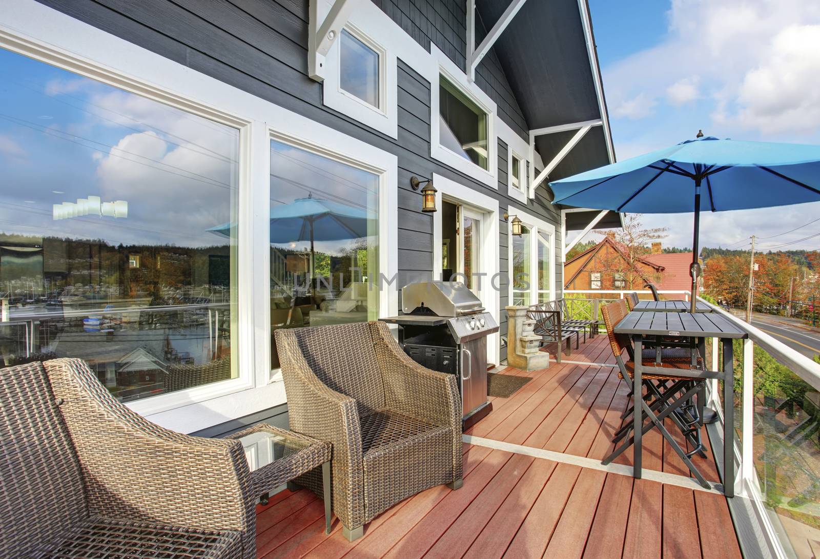 Northwest traditinal wooden deck with large windows, chairs and tables.